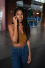 Retrato de atraente jovem afro-latina falando em um smartphone em um shopping comercial, Colômbia — Fotografia de Stock