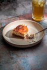 Зверху апетитний пиріг кладуть на керамічну тарілку зі склянкою напою з льодом в ресторані — стокове фото