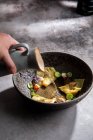 Crop anonyme Köchin Zugabe von Brühe in Schüssel mit traditionellen japanischen Knödel während der Zubereitung von Mahlzeit im Restaurant — Stockfoto