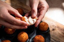 From above of crop anonymous chef demonstrating filling of cheese ball in crispy crust in kitchen — Stock Photo