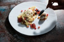 De dessus de la culture personne anonyme mangeant omelette délicieuse décorée avec des graines de grenade — Photo de stock