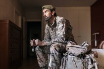 Niedriger Winkel ernsthafter Mann in Militäruniform bereitet sich auf den Militärdienst vor — Stockfoto