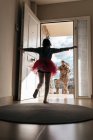 Baixo ângulo de filha surpreendida correndo em direção ao pai retornando do serviço militar em pé na porta — Fotografia de Stock