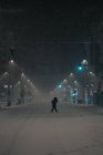 Vista lateral do homem anônimo em outerwear andando na estrada no inverno nevado em Madrid Espanha — Fotografia de Stock