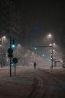 Blick zurück auf einen anonymen Mann in Oberbekleidung, der im verschneiten Winter in Madrid auf der Fahrbahn läuft — Stockfoto