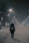 Vue arrière de l'homme anonyme en vêtements de dessus marchant sur la chaussée en hiver neigeux à Madrid Espagne — Photo de stock