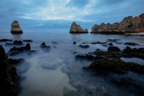 Dall'alto pittoresca vista delle formazioni rocciose sulla costa oceanica sotto il cielo del tramonto a Praia do Camilo, Algarve Portogallo — Foto stock