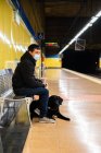 Passageiro masculino em máscara com cão guia na estação de metro — Fotografia de Stock
