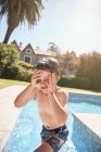 Cheerful shirtless little boy yelling while jumping into pool water during summer holidays in countryside — Stock Photo