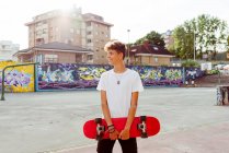 Красивый кавказский подросток со скейтбордом на улице — стоковое фото