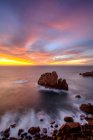From above picturesque view of rocky formations in ocean coastline under sunset sky in Praia do Camilo, Algarve Portugal — Stock Photo