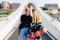 Двоє красивих хлопчиків-підлітків зі скейтбордом, що стоять на мосту — стокове фото