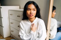 Long hair brunette Asian woman wearing a white sweater and looking away — Stock Photo