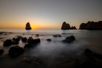 Vue de dessus pittoresque de formations rocheuses sur le littoral océanique sous le coucher du soleil à Praia do Camilo, Algarve Portugal — Photo de stock
