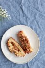 Вид зверху смачне яблучне тістечко на керамічних тарілках біля свіжої квітки на крейдованому текстилі — стокове фото