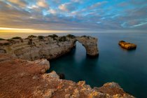 З - над мальовничого краєвиду високі скелясті утворення в океанічній береговій лінії під заходом сонця в Прая-да-Абандейра, Алгарве Португалія. — стокове фото