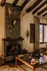 Interior de casa rústica insinuación con chimenea y cuernos de ciervo colgando en la pared - foto de stock