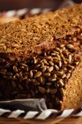 Крупним планом смачний нарізаний хліб з коричневою скоринкою і хрустким насінням соняшнику зверху у плетеному кошику — стокове фото