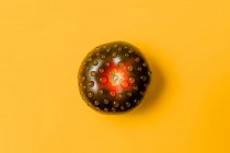 Vue aérienne de la tomate mûre avec gouttes d'eau pure représentant beignet avec glaçage au chocolat concept — Photo de stock