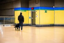 Blind man walking with guide dog in subway — Stock Photo