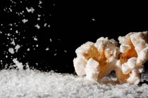 Крупный план вкусного попкорна на слое соли — стоковое фото