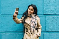 Cabello largo morena mujer asiática utilizando el teléfono móvil en la calle - foto de stock