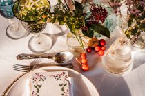 Hohe Winkel der servierten Festtafel mit Kristallgläsern Serviette auf Teller in der Nähe von frischen Blumen für Hochzeit und Menükarte — Stockfoto