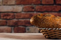 Side view of tasty cut bread with brown crust and crunchy sunflower seeds on top in wicker basket — Stock Photo