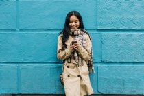 Long hair brunette Asian woman using mobile phone in the street — Stock Photo