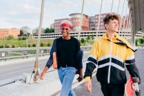 Zwei hübsche Teenager mit Skateboard auf der Brücke — Stockfoto