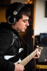 Вид збоку концентрованого сліпого гітариста, який грає на музичному інструменті під час репетиції мелодії вдома — стокове фото