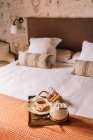 Du dessus du plateau avec gaufres avec thé dans une tasse et bouilloire placée sur un lit doux le matin — Photo de stock