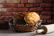 Смачний хліб з цільнозернових у солом'яному кошику на столі — стокове фото
