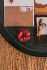 Вид зверху на білі вітальні листівки, розміщені на чорному круглому підносі з яскравими рослинами на плетеній поверхні під час весільного торжества — стокове фото
