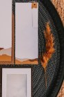 Вид зверху на білі вітальні листівки, розміщені на чорному круглому підносі з яскравими рослинами на плетеній поверхні під час весільного торжества — стокове фото