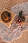 Вид зверху на модний капелюх на подушці, розміщений поруч з декоративними елементами з квітами на пухнастій плед на вулиці під час весілля — стокове фото