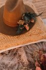 Вид зверху на модний капелюх на подушці, розміщений поруч з декоративними елементами з квітами на пухнастій плед на вулиці під час весілля — стокове фото