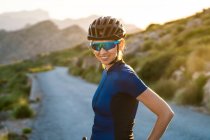 Mulher feliz em sportswear com capacete de pé com bicicleta na natureza — Fotografia de Stock
