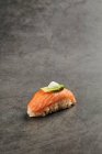Высокий угол вкусовых суши нигири с ломтиком лосося на рисе, увенчанном тонким ломтиком авокадо и сливочным сыром — стоковое фото