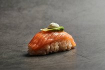 Grand angle de sushi nigiri appétissant avec tranche de saumon sur du riz garni d'une fine tranche d'avocat et de fromage à la crème — Photo de stock