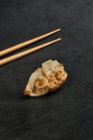 Angolo alto di gyoza fritti cibo tradizionale orientale collocato con bastoncini di bambù sul tavolo grigio — Foto stock