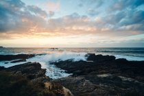 Pintoresco paisaje de costa escarpada rocosa cubierta con césped lavado por salpicaduras de olas - foto de stock