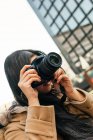 Etnico asiatico fotografo femminile ripresa foto sulla macchina fotografica professionale sulla strada della città — Foto stock
