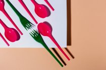 Overhead view of colorful eco friendly cutlery on pastel background — Stock Photo