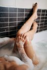 Dall'alto di femmina seducente giovane che si trova in vasca da bagno con schiuma in casa — Foto stock