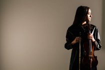 Violoniste féminine debout avec instrument de musique et les yeux soigneusement fermés — Photo de stock