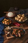 Mala Tofu und Yuxiang, chinesische vegane Gerichte, dazu eine Schüssel Reis, Blumenkohl, Sojasauce und eine japanische Teekanne auf einem mit Stoffen dekorierten Holztisch — Stockfoto