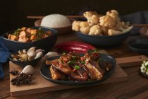 Mala tofu e yuxiang, piatti vegani cinesi, accompagnati da una ciotola di riso, cavolfiore, salsa di soia e una teiera giapponese su un tavolo di legno decorato con tessuti — Foto stock