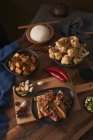 Mala tofu і yuxiang, китайські веганські страви, в супроводі миші рису, цвітної капусти, соєвого соусу і японського чайника на дерев'яному столі, прикрашеному тканинами. — стокове фото