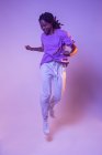 Dynamische afroamerikanische Teenie-Tänzerin springt auf, während sie im hellen Studio Tanzbewegungen vorführt — Stockfoto